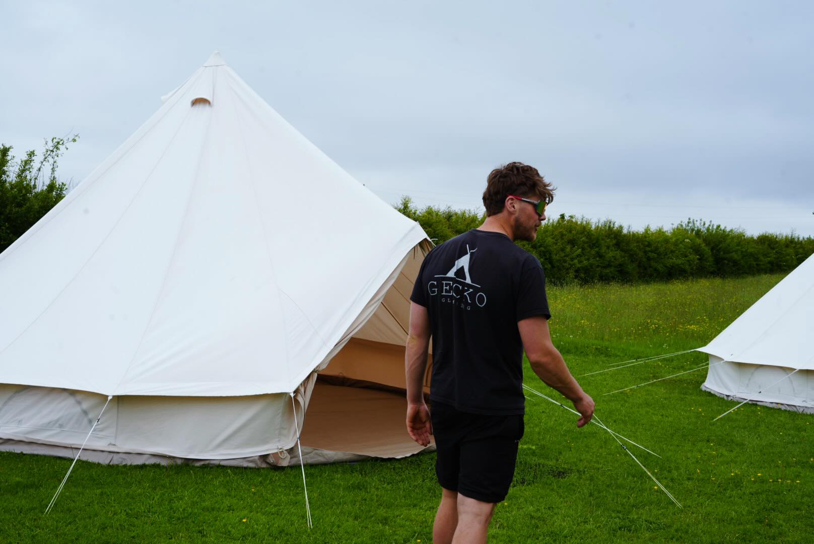 Gecko team setting up bell tents on a lawn